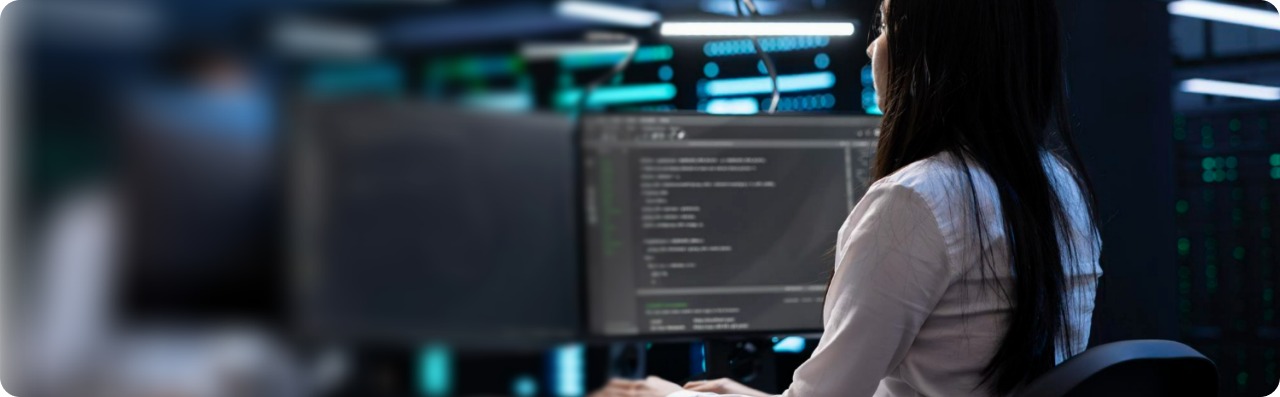 Engineer reviewing code on a monitor in a server room